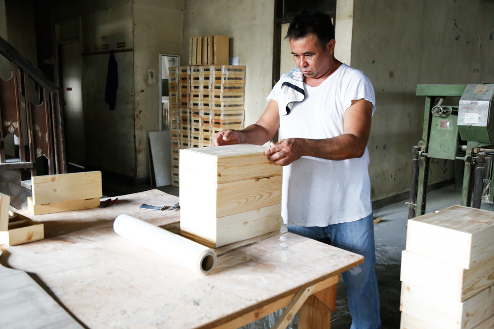 Another Balai Kamay carpenter measuring blocks of wood