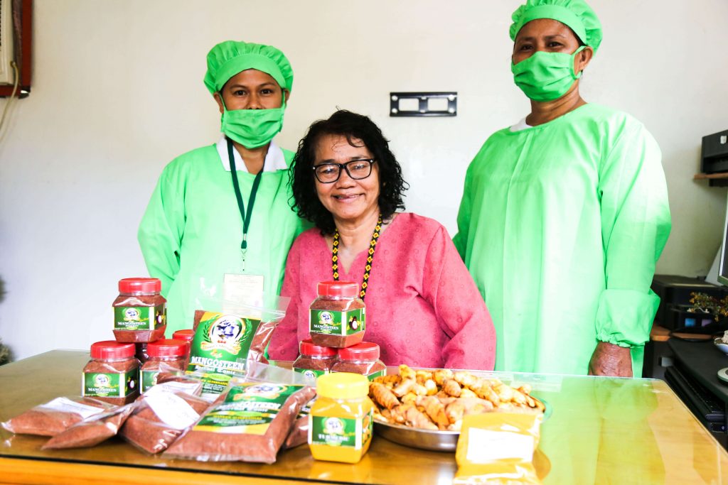 Luz, the owner of Manna’s Alternative Herbal Products, poses with two of her staff showcasing some of their products