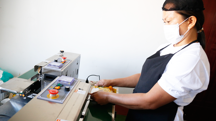 Mango King employee packing the dried mangoes