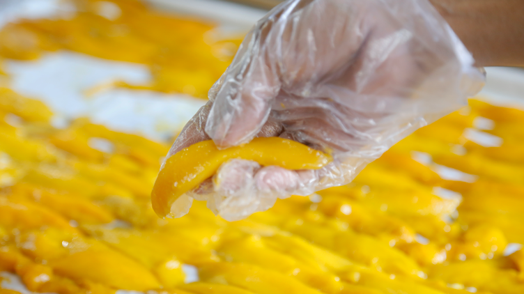 Strips of raw mangoes being processed