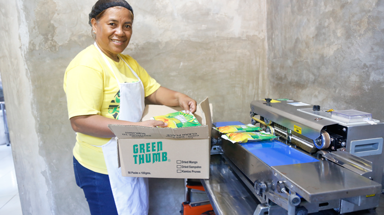 Evelyn Grace packaging the dried mangoes