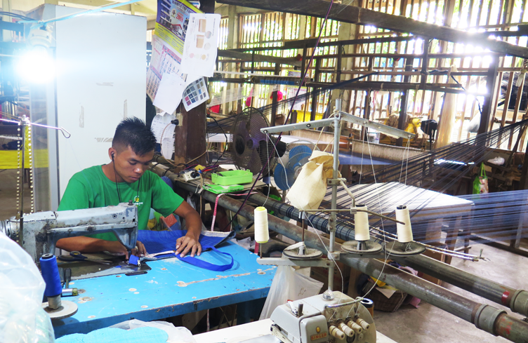 A TLMPC member sewing the handle of a hand-crafted bag