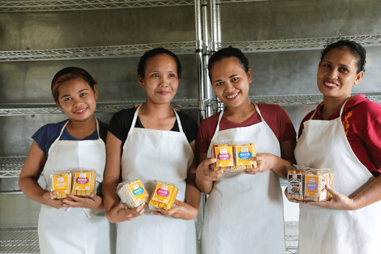 Four Baker's Field employees holding up various packets of biscocho