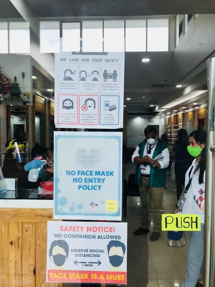 COVID-19 safety signages at the entrance of a barbershop in a mall in Region 9