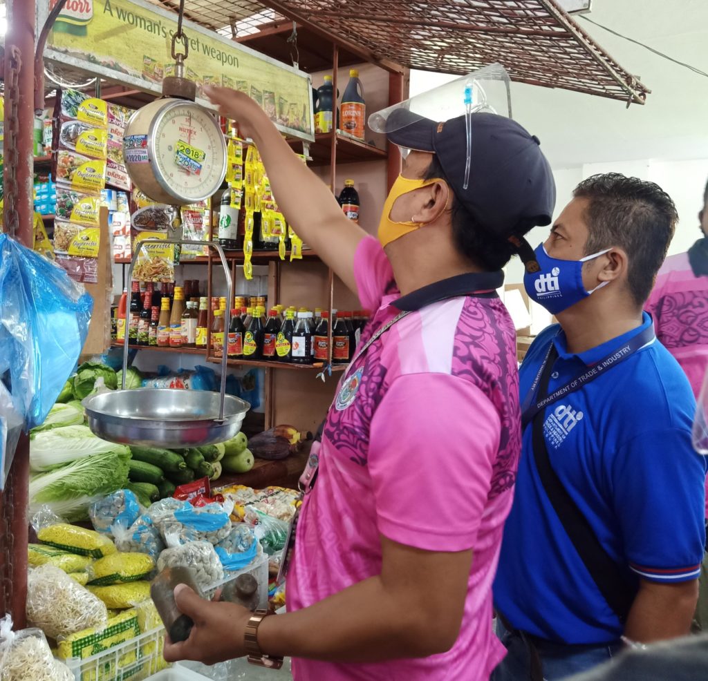 Representatives from DTI and Nagcarlan LGU conducting an inspection of business establishments at the temporary public market in Nagcarlan