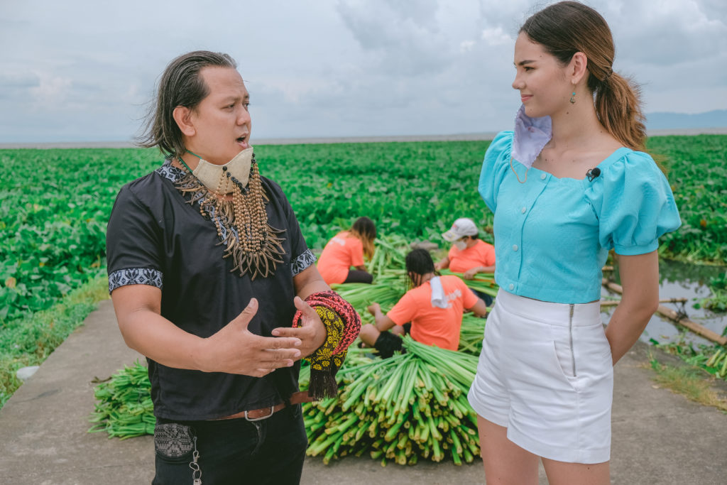 Catriona Gray interviewing Renel Batralo of Rolyo Likha in front of a lake with water hyacinth