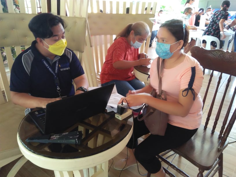 SBCorp technical staff assigned at DTI-Davao de Oro, Romeo Arana, serves a client during a caravan in Pantukan.