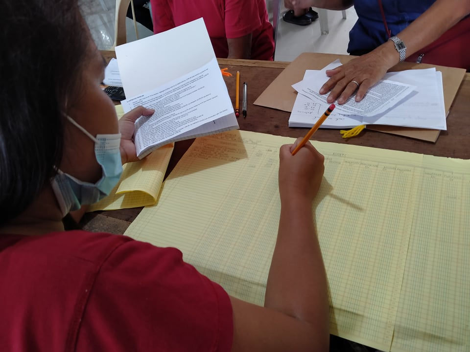 Farmer participants attentively adhere to the activities and can be seen inputting financial records in the spreadsheet.