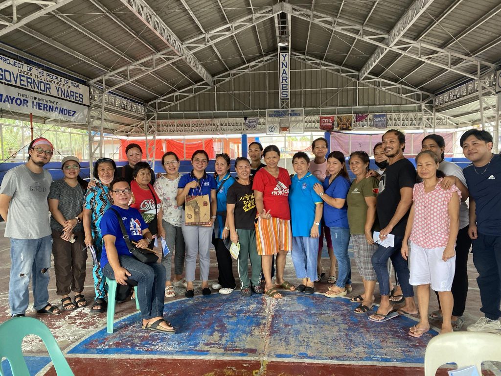Group of diverse individuals posing together in a community hall.