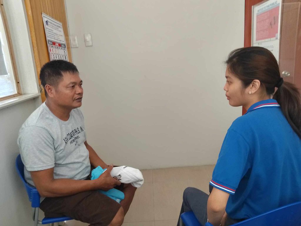 Eduardo Ricardo and a representative from DTI-Region IV-A sit facing each other in a room, engaged in conversation.