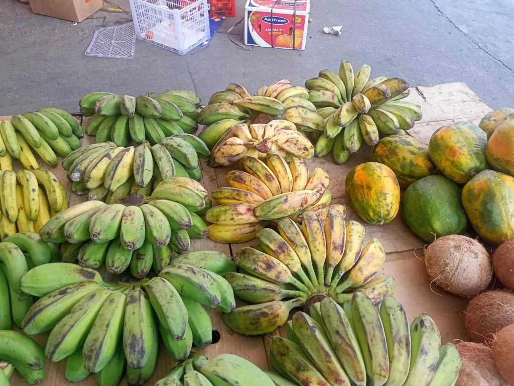 A variety of bananas on a table at a market.