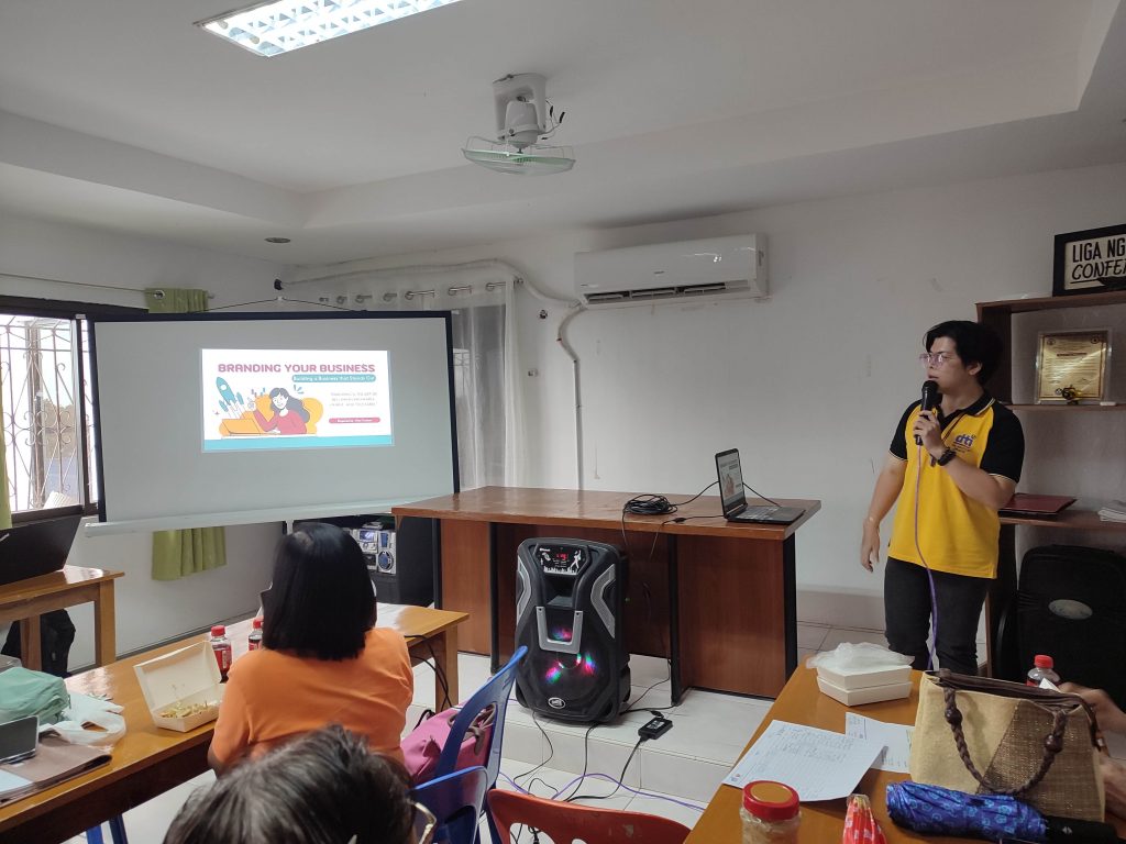 Presenter discussing "Branding Your Business" in a seminar room.
