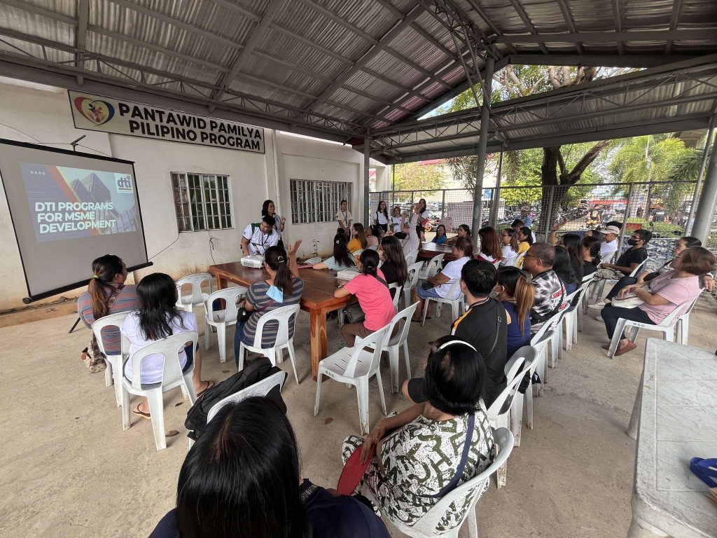 Participants attending a seminar on 'DTI Programs for MSME Development', with a facilitator presenting key initiatives to support local entrepreneurs.