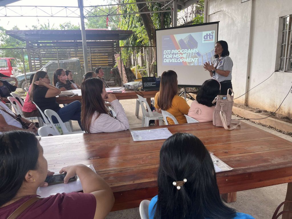Participants attending a seminar on 'DTI Programs for MSME Development', with a facilitator presenting key initiatives to support local entrepreneurs.