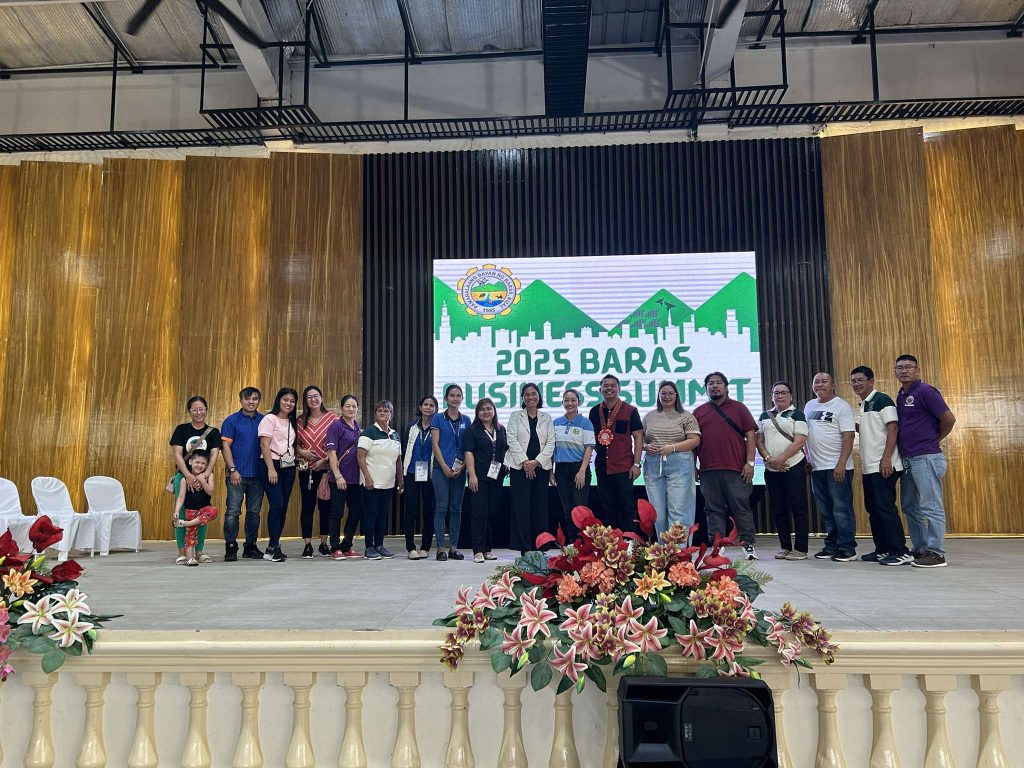 Group photo taken at the 2025 Baras Business Summit on a decorated stage.