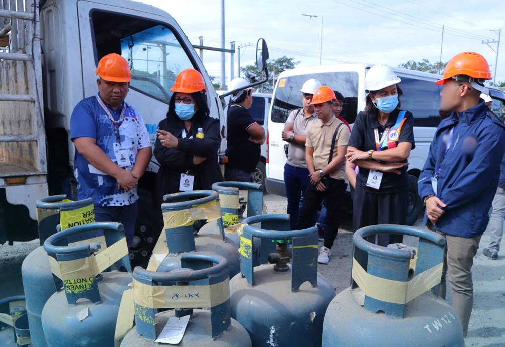Regional Director Membrere with the rest of DTI Region 1 staff inspecting confiscated LPG tanks.