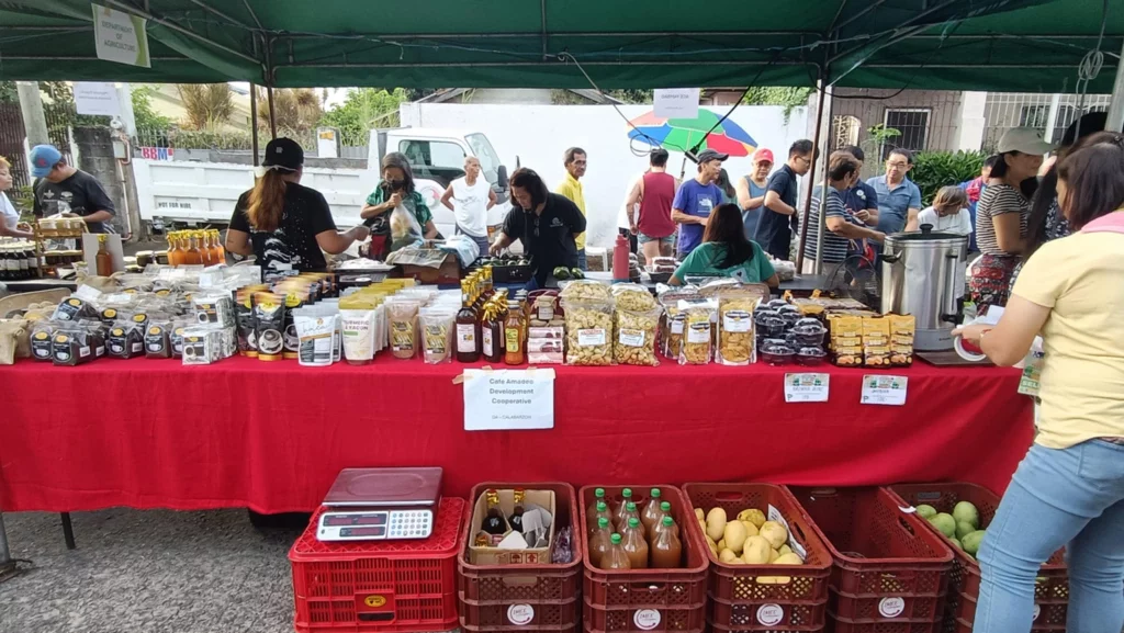 This image captures the lively atmosphere of a local market, showcasing the diverse range of goods available and the interactions between vendors and customers.