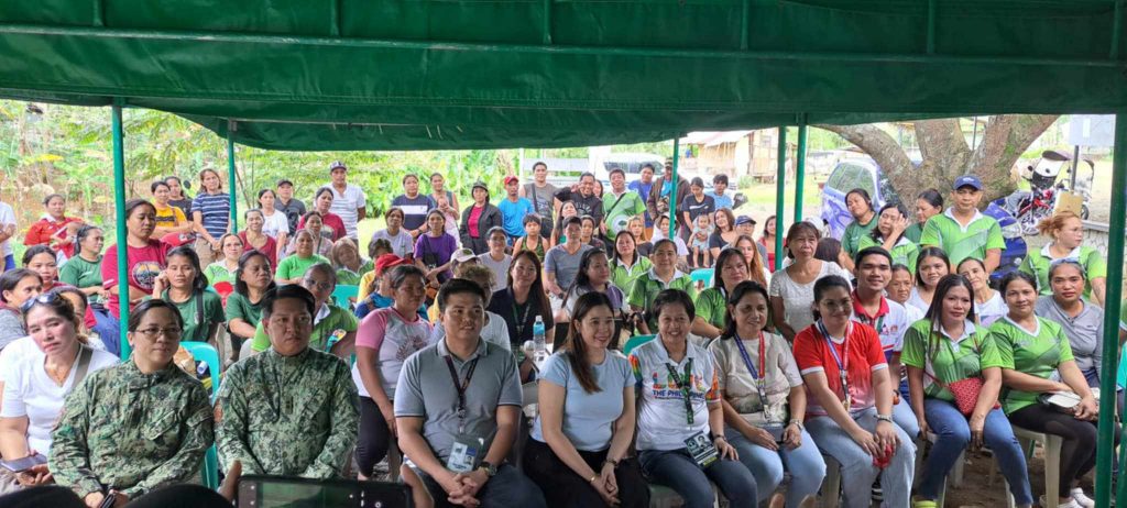 A group photo of local officials, DTI 4-A Rizal representatives, and community members at the Career Development Support Program in Rodriguez, Rizal, held under a green canopy.