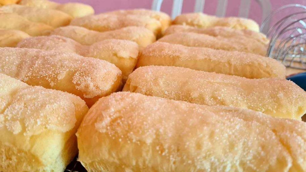 Sugar-coated, golden-brown pastries, fresh from the oven, convey warmth and deliciousness.