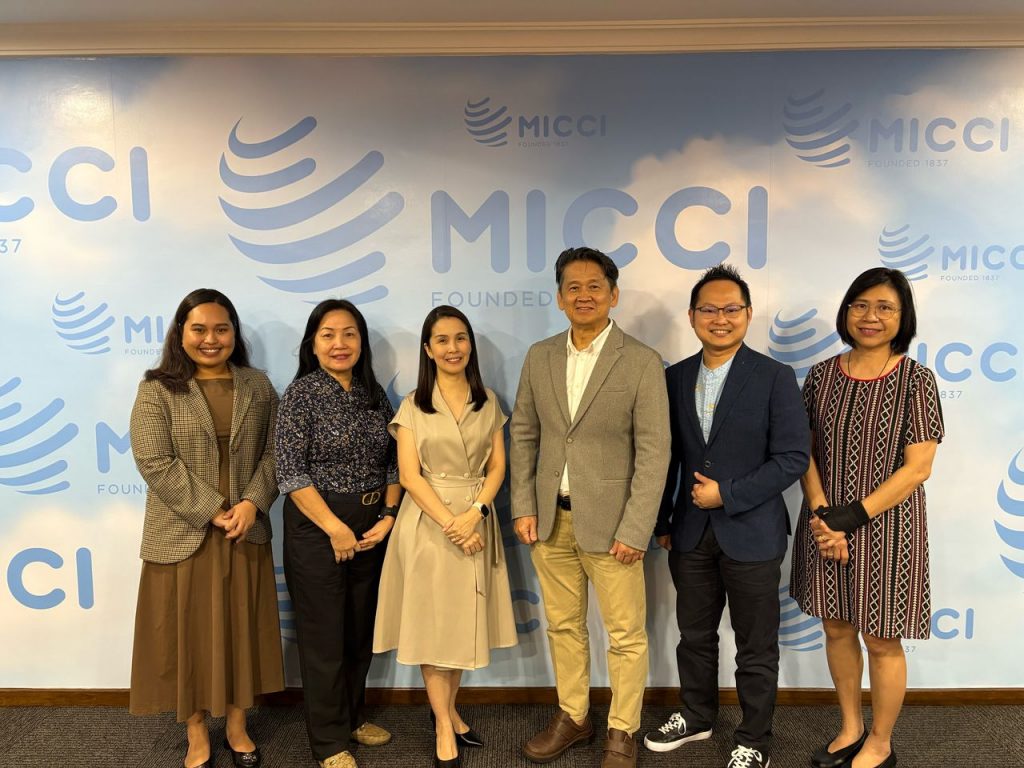 The meeting brought together key business leaders, including Mr. Martin Ang, MCMTC President and Director of Julie’s, Ms. Mag Ng, MCMTC Secretary-General and Compliance Director of Mega Fortris Group, Mr. Andy Yeap, MCMTC Deputy Secretary-General and Chief Operating Officer of Kawan Food Manufacturing Sdn Bhd, and Ms. Karen Fairclough-Ng, MCMTC Executive Director. Representing PTIC-KL were Ms. Norjamin G. Delos Reyes, Commercial Counsellor, and Ms. Cassandra Anwar, Trade Assistant. A group photo of six individuals standing in front of a blue backdrop with the "MICCI" logo. The meeting attendees include business leaders and representatives from MCMTC and PTIC-KL. They are dressed in professional attire, standing closely together, and smiling at the camera. The setting appears to be an indoor corporate or conference space.