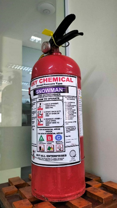 A red fire extinguisher sitting on top of a wooden pallet