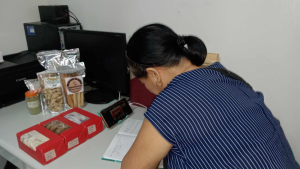 Loreta Gersava is surrounded by packaged food products and recording information.