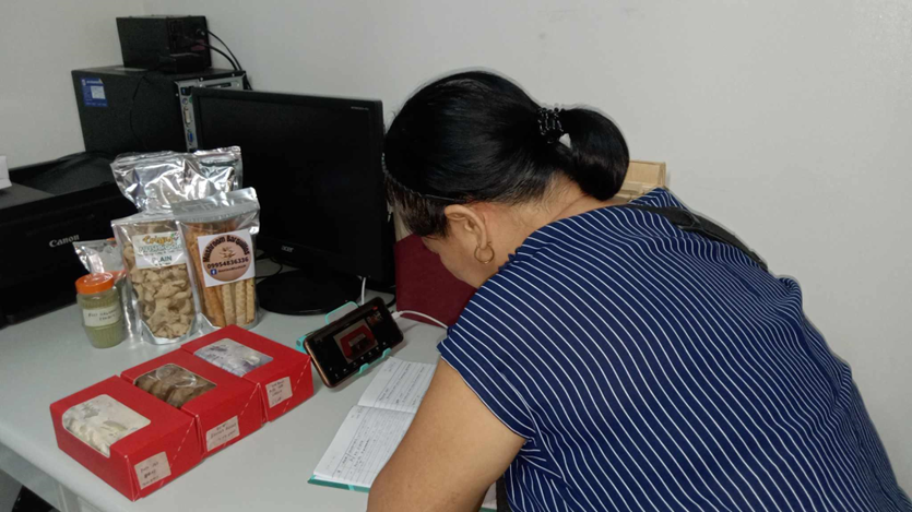 Loreta Gersava is surrounded by packaged food products and recording information.