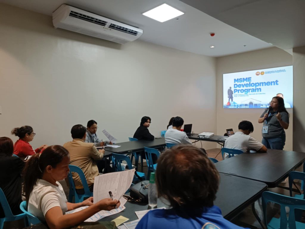 A training session focused on an "MSME Development Program" is in progress, with a speaker addressing participants seated at tables. The setting appears to be a conference or training room.