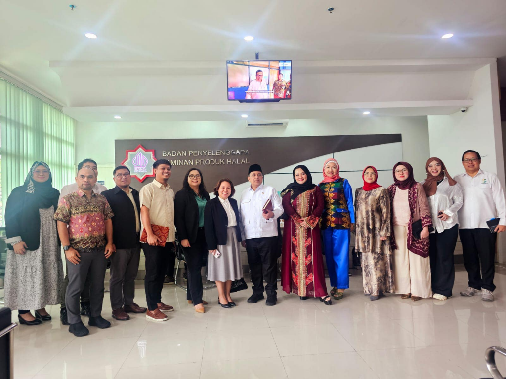 A group photo of Philippine and Indonesian representatives standing in a meeting room with a “Badan Penyelenggara Jaminan Produk Halal” sign in the background. The participants wear formal and cultural attire, reflecting the collaboration on halal certification initiatives. Photo courtesy of the Philippine Embassy to Indonesia.