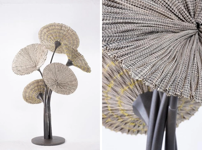 Art installation titled 'Raffia Flowers' by Olivia d’Aboville, featuring handwoven raffia polyester textiles from Cebu Interlace, pleated into circular conic shapes resembling flowers. The textile flowers are mounted on metal stems crafted in collaboration with Industria Edition. The left side shows the full arrangement, while the right side offers a close-up of the detailed weaving and pleating.