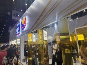 DTI Philippines booth at Cosmobeauté Philippines 2025, featuring golden pillars, product displays, and visitors engaging with exhibitors. The booth highlights Filipino MSMEs and innovations in the beauty industry.