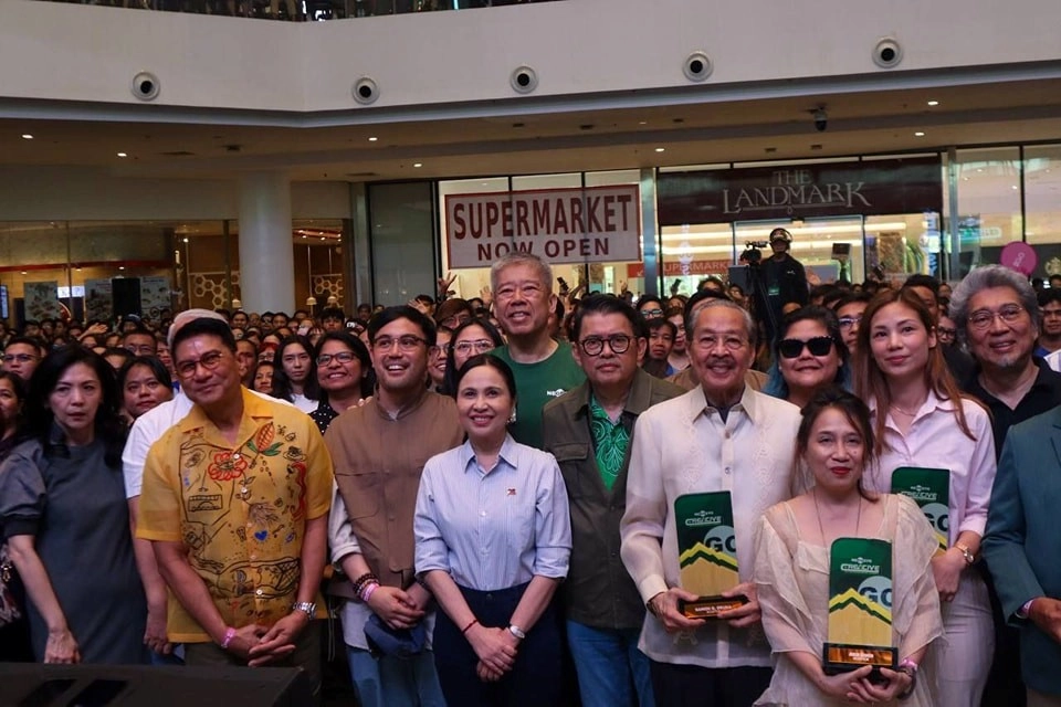 DTI Secretary Cristina A. Roque joins Go Negosyo Founder Jose Ma. A. Concepcion III in awarding Filipino creative icons during the Creative Entrepreneurship Summit 2025 at a mall venue, with signage for 'The Landmark' and 'Supermarket Now Open' visible in the background.