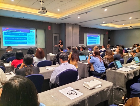 Participants attend a training session on the Philippine Free Trade Agreement (FTA) Integrated Platform at the SMX Convention Center in Clark, Pampanga. A presenter stands beside a large screen displaying information about the Digital FTA System, while attendees use laptops and take notes. The session is part of a DTI-led initiative to equip exporters with tools to maximize FTA benefits.