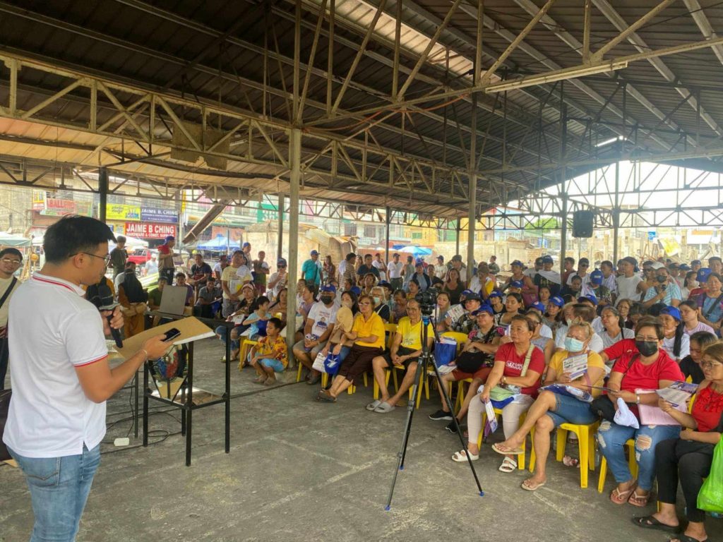 Government officials from Senator Bong Go’s office and DTI-Laguna provide relief assistance and introduce livelihood recovery programs to fire victims at Santa Cruz public market, highlighting the Pangkabuhayan sa Pagbangon at Ginhawa initiative and collaborative disaster response efforts.