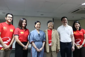 DTI Secretary Cristina Roque (center, in blue dress) with Jollibee Group representatives and MSME participants during the “Joy in Learning” session, standing together for a group photo
